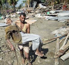 Azahar Ali is carried by a relative through the rubble on Monday, days after the cyclone hit the area in Patargata, 200 kilometres south of Dhaka.