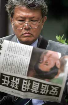 A Japanese man reads a special edition newspaper announcing the resignation of Japanese Prime Minister Shinzo Abe in Tokyo Wednesday.