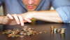 A man counts his coins on a tabletop. iStockphoto