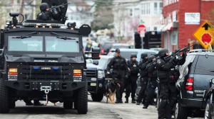 SWAT members aim their guns as they search for the remaining bombing suspect