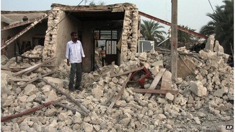 Man standing in rubble in Shonbeh, southern Iran (09/04/13)