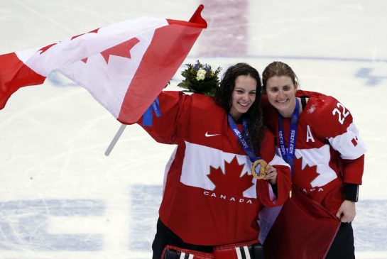 Goalkeeper Shannon Szabados of Canada (left) and Hayley Wickenheiser of Canada celebrate after the medal ceremony in the women's ice hockey tournament at the 2014 Winter Olympics, Friday, Feb. 21, 2014, in Sochi, Russia. Canada won gold after defeated Team USA 3-2 in overtime.
