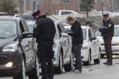 Police interview people leaving the parking lot of the A. Grenville and William Davis Courthouse in Brampton March 28, 2014, after a shooting inside the court.