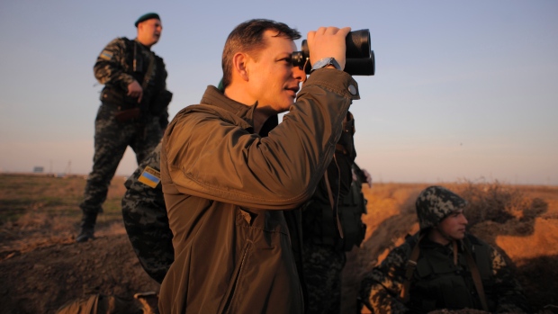 Oleh Lyashko, a lawmaker who supported the protests that ousted Viktor Yanukovych and his government, looks at Russian positions as he visits Ukrainian troops.