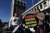 Protesters drum outside the court in Guatemala City where former president Otto Perez Molina is expected to arrive to face corruption charges following his overnight resignation, on Thursday, Sept. 3. The sign reads, "Get out Otto Perez, Guatemala doesn't want you."