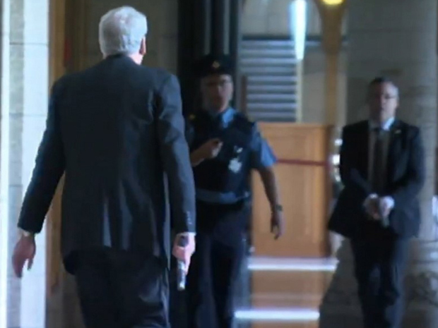 Kevin Vickers, left, the sergeant-at-arms of the House of Commons, is shown in this still image taken from a CBC video in the Parliament's Hall of Honour carrying a gun on Wednesday Oct. 22, 2014.  