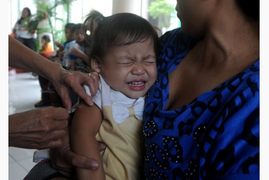 A mother holds her child as she receives a measles vaccine in Manila last month. The country has launched a nationwide campaign against the disease, targeting 13 million children 5 and younger.
