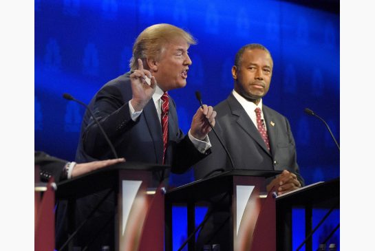 Ben Carson, right, watches as Donald Trump speaks during the third Republican presidential debate at the University of Colorado in Boulder on Wednesday night.
