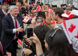 Le Premier ministre Stephen Harper salue la foule lors de la célébration de la Fête du Canada, sur la colline du Parlement.