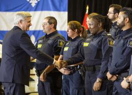 Le PM Harper échange une poignée de main avec des agents de la GRC à la suite d’une annonce à Montréal.