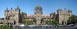 A brown building with clock towers, domes and pyramidal tops. Also a busiest railway station in India.[281] A wide street in front of it
