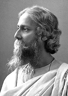 Late-middle-aged bearded man in white robes looks to the left with serene composure.