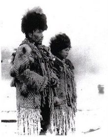 "Black and white photograph of Skwxwu7mesh Chief George from the village of Senakw with his daughter in traditional regalia."
