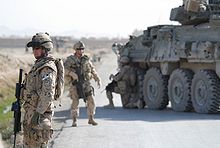 Canadian Grenadier Guards in Kandahar Province standing by road with armored car