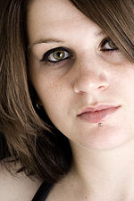 Woman with hazel eyes and labret piercing gazes at the camera.jpg