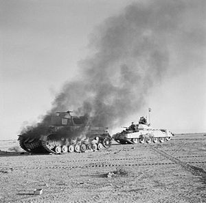 Crusader tank passing burning Panzer IV tank during Operation "Crusader"