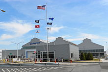 Boeing plant in Ridley Park, Pennsylvania - a building with aluminum siding, parking lot in front, and a flagpole with seven flags