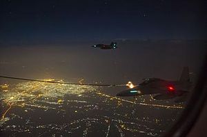 Two Royal Australian Air Force Super Hornet aircraft conduct air to air refuelling with a RAAF Multi Role Tanker Transport aircraft by night over the skies of Iraq.jpg
