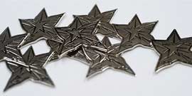 Close-up of silver metallic embossed stars, slightly imperfect in shape.