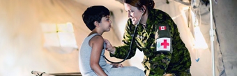 Une médecin militaire s'occupe d'un enfant.