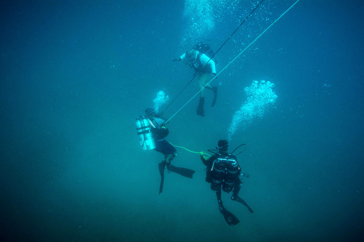 Le matelot-chef Gord McMillan (à droite), plongeur démineur de l’Unité de plongée de la Flotte (Atlantique), donne des directives à des plongeurs caribéens lors d’une plongée en profondeur pendant l’exercice TRADEWINDS 2016 en Discovery Bay, Jamaïque, 15 juin 2016  (Photo : Sgt Yannick Bédard, Caméra de combat des Forces canadiennes)