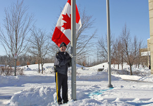 Commissioner Paulson raises the Canadian flag.