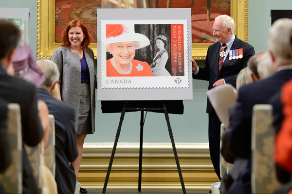 Son Excellence a ensuite aidé Mme Siân Matthews, présidente du Conseil d’administration et présidente du Comité de contrôle des initiatives stratégiques de Poste Canada, à dévoiler un timbre commémoratif.