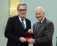 Mr. Diarmuid Nash accepted the medal on behalf of Maki and Associates/Moriyama & Teshima Architects for The Delegation of the Ismaili Inamat: Architecture of Peace and Plurality. On a prominent site in Ottawa, this secular facility, conceived by the Aga Khan as a sanctuary for peace, diplomacy and global pluralism, powerfully expresses its
mission through an architectural bridging of dichotomies: modernity + tradition, light + dark, indoor + outdoor, west + east. Clad in luminous crystallized glass panels, the Delegation Building focuses upon two symbolic meeting spaces: the glass-ceilinged atrium, inspired by natural stone crystals and Islamic geometries, and the open-air
courtyard, inspired by chahar bagh, the traditional Persian-Islamic walled garden. 