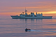 HMCS MONTREAL sails in the sunrise off the Atlantic seaboard on 20 November 2005. A zodiac, with members of HMCS FREDERICTON, head for HMCS WINDSOR, a VICTORIA Class submarine to exchange passengers during Canadian Fleet Operations. Photo:Sgt Roxanne Clowe
