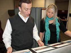 Two communications employees looking at posters