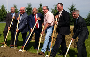 Minister MacAulay and industry representatives break ground with shovels.