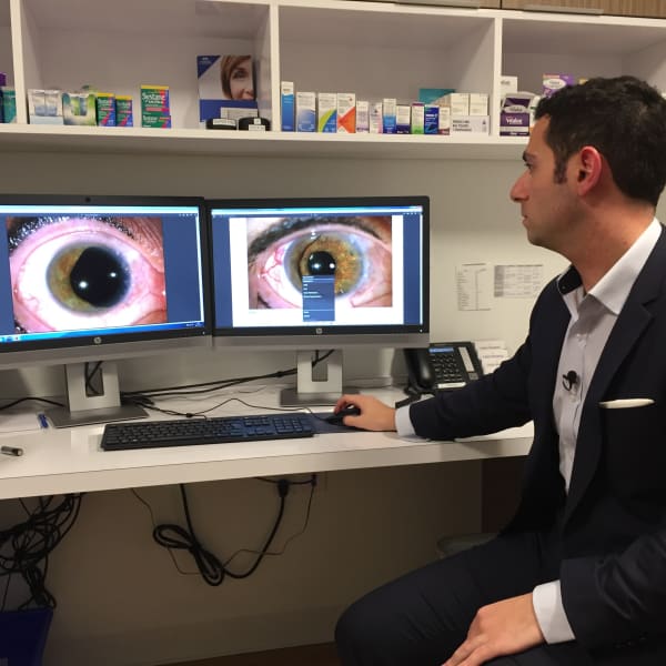 L'ophtalmologiste Mazen Choulakian montre sur un ordinateur une photo d'un iris avant l'opération et après l'implantation d'un iris artificiel.  