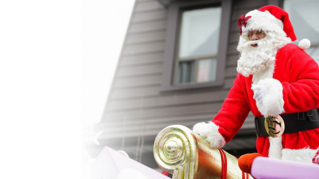 Le père Noël dans son habit traditionnel en rouge et blanc dans son traîneau doré et rouge.