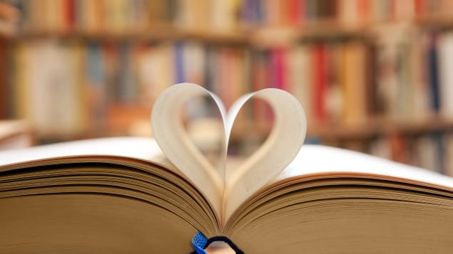 Un livre ouvert dont les pages pliées forment un coeur. 