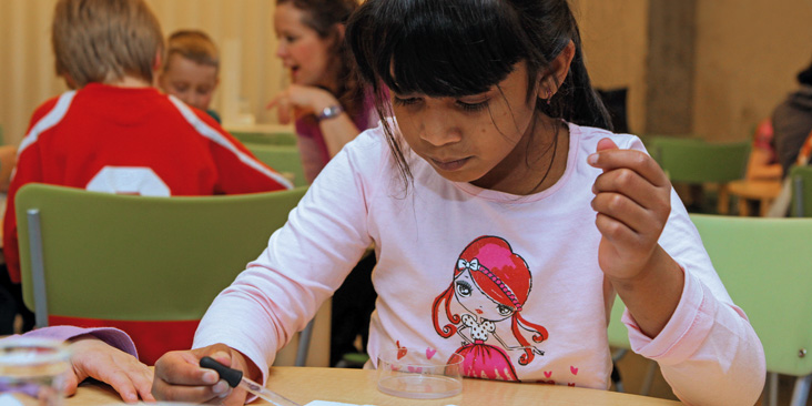 A girl does a science activity at a table.