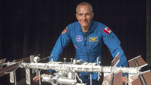 L'astronaute canadien David Saint-Jacques devant une maquette de la Station spatiale internationale.