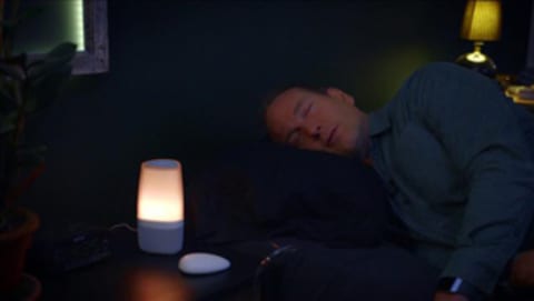Un homme dort à côté d'un objet lumineux. 