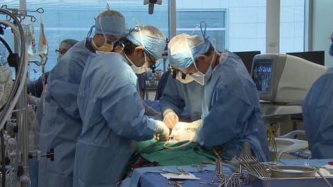 Des chirurgiens au travail autour d'une table d'opération