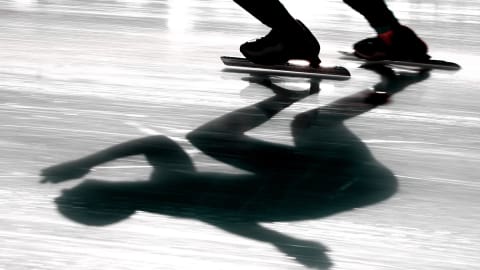 Gros plan sur la glace oèu l'on voit l'ombre du patineur