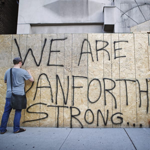 Des Torontois lancent un appel à la solidarité en écrivant des messages sur le mur d'un édifice en rénovation.