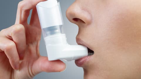 Une femme asthmatique utilise une pompe.