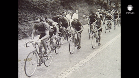 Une image en noir et blanc de cyclistes à la file datant de 1937.