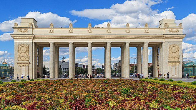 Photograph of the colossal colonnade at Gorky Park's main portal in 2016, a large flowerbed in the forefront