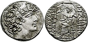 Photograph of of a Roman coin struck in imitation of the coins of Philip I Philadelphus of Syria, depicting Philadelphus in left-facing profile on the obverse and sitting in his throne on the reverse