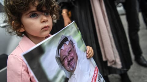 Une petite fille tenant le portrait du journaliste durant une manifestation.