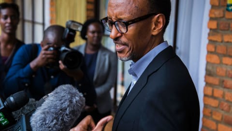 Plusieurs micros devant le visage, le président du Rwanda Paul Kagame répond aux questions des journalistes.