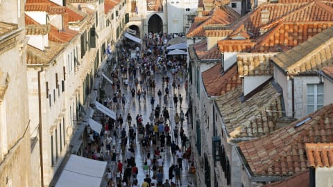 Vue en hauteur d'une rue piétonne de la vieille ville de Dubrovnik où des dizaines de touristes s'entassent.
