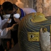 Le ministre égyptien des Antiquités Khaled Al-Anani examine un sarcophage découvert dans une nouvelle tombe à Louxor.  