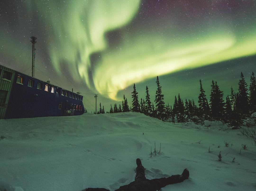 Making snow angels under the northern lights in Churchill, Manitoba