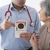 Un médecin parle à une patiente. Il tient une brochure qui dit : Ostéoporose, êtes-vous à risque?